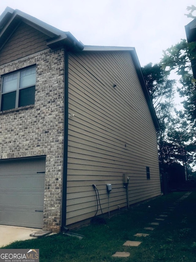 view of home's exterior with brick siding and an attached garage