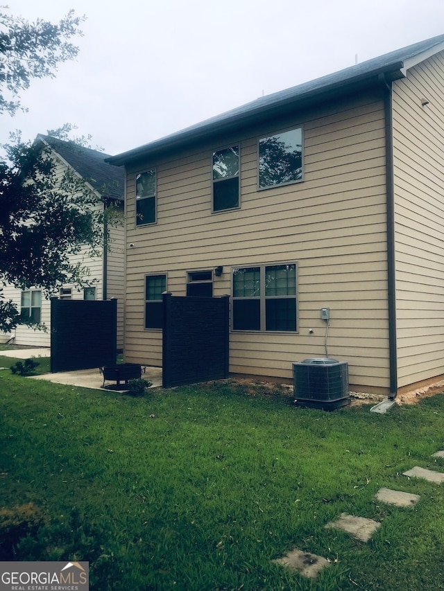 view of side of property featuring a lawn, central AC, and a patio