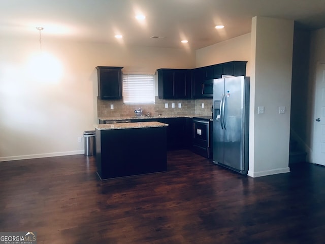 kitchen with decorative backsplash, dark hardwood / wood-style floors, appliances with stainless steel finishes, sink, and a center island