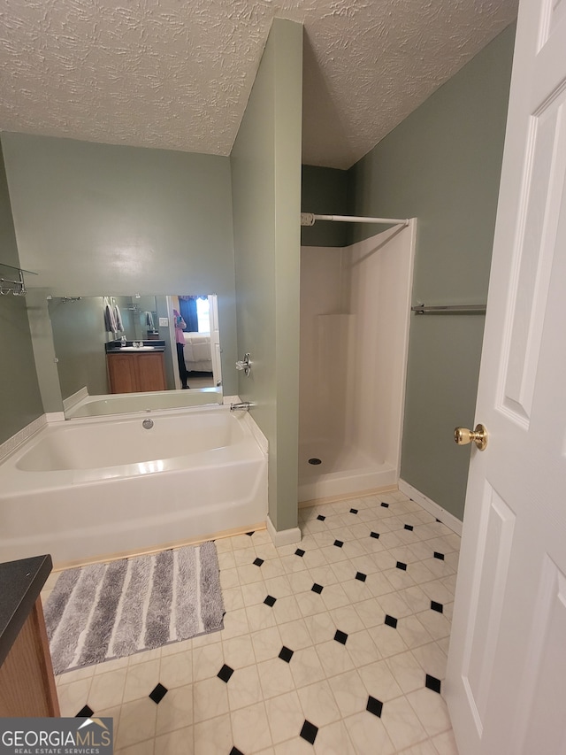 bathroom featuring a textured ceiling, tile patterned floors, and vanity