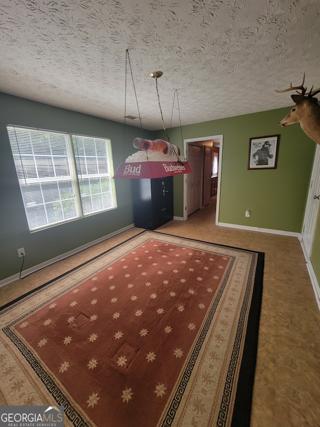 recreation room with a textured ceiling