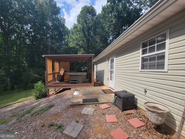 view of patio / terrace featuring a wooden deck and a hot tub