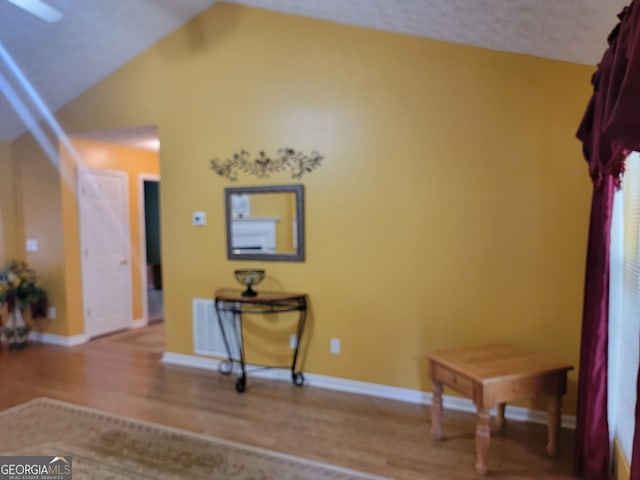 interior space featuring hardwood / wood-style flooring and vaulted ceiling