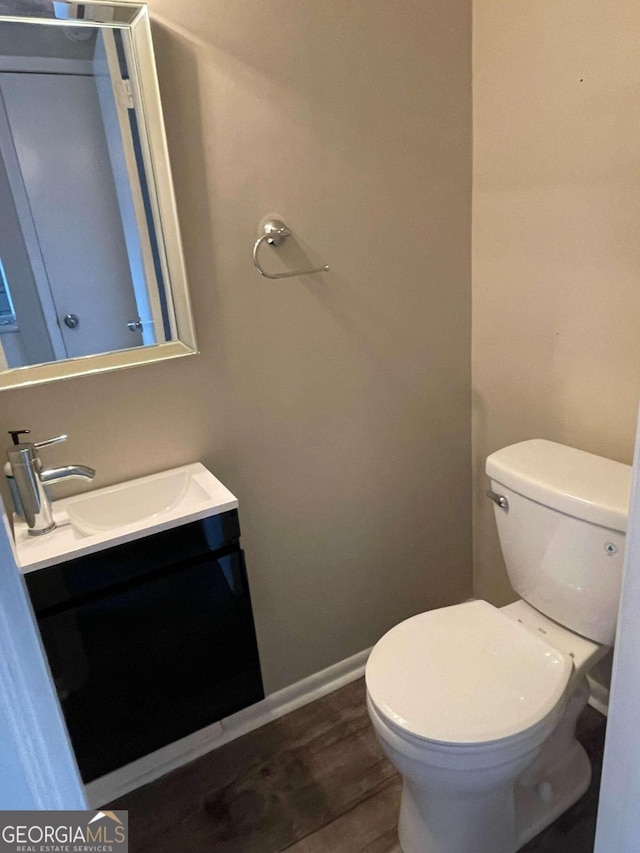 bathroom with vanity, toilet, and wood-type flooring