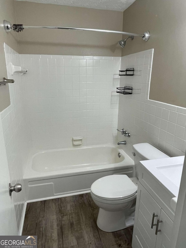 full bathroom featuring toilet, tile walls, a textured ceiling, vanity, and hardwood / wood-style floors