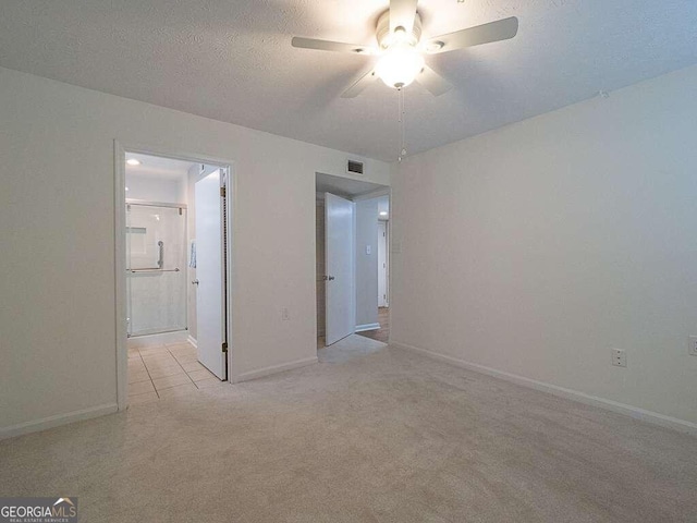 carpeted empty room with a textured ceiling and ceiling fan