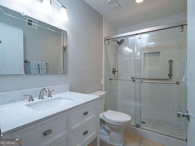 bathroom featuring tile patterned flooring, vanity, an enclosed shower, and toilet