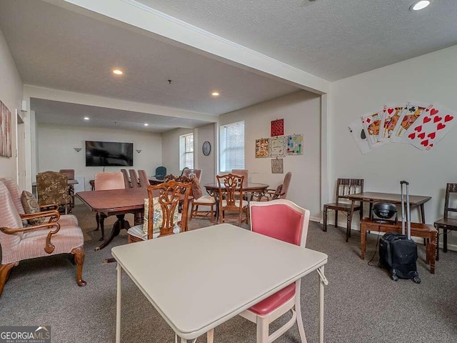 carpeted dining area featuring beamed ceiling and a textured ceiling