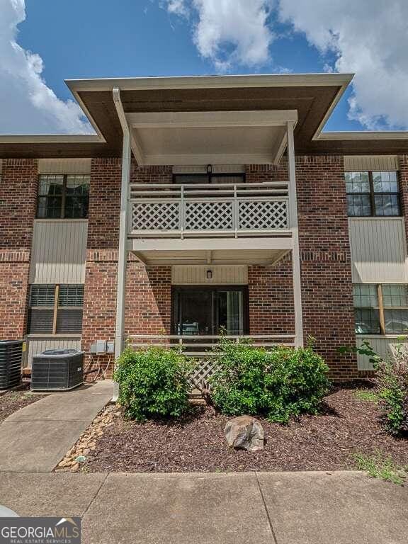 view of front of property featuring a balcony and central AC