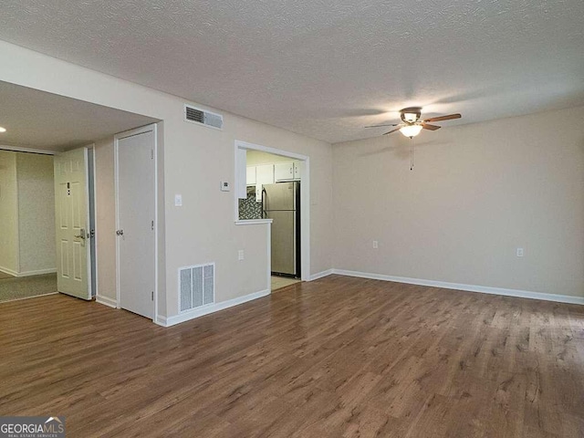 unfurnished living room featuring ceiling fan, a textured ceiling, and hardwood / wood-style flooring