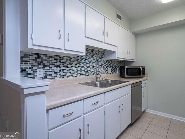 kitchen with white cabinetry, sink, stainless steel appliances, backsplash, and light tile patterned floors