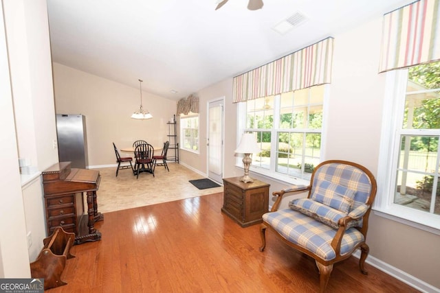 living area with hardwood / wood-style flooring, vaulted ceiling, and ceiling fan