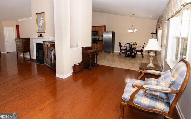 living area with dark hardwood / wood-style floors, a chandelier, and high vaulted ceiling