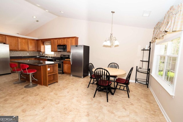 kitchen with a healthy amount of sunlight, stainless steel appliances, a kitchen island, and backsplash