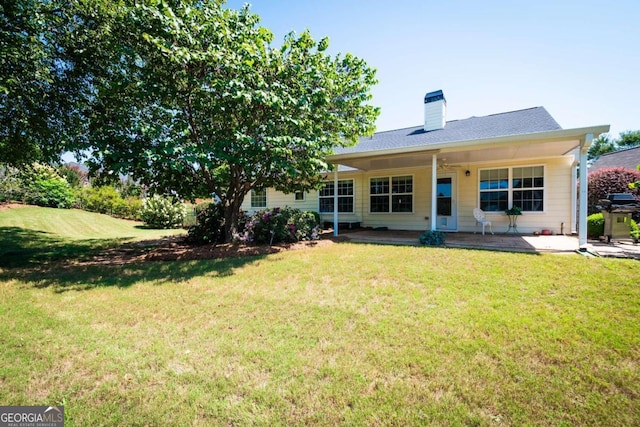 back of house featuring a patio area and a lawn