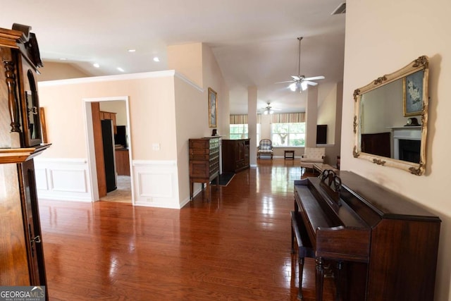 living room featuring lofted ceiling, ornamental molding, dark hardwood / wood-style floors, and ceiling fan