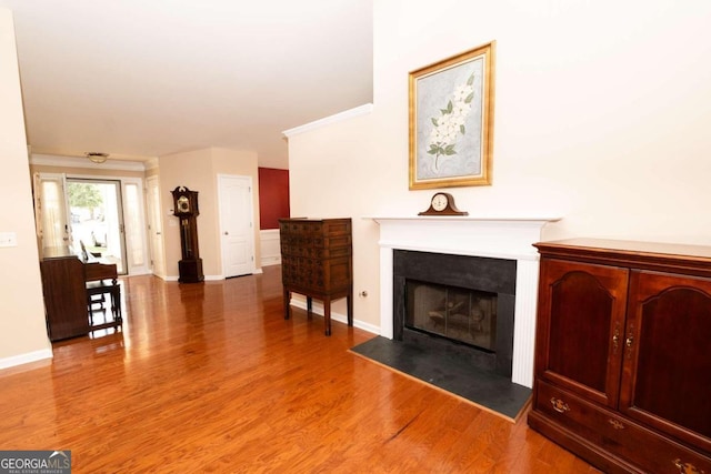 unfurnished living room featuring crown molding and wood-type flooring