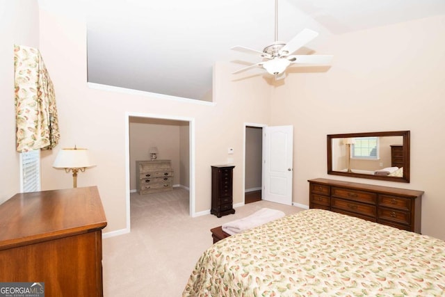 carpeted bedroom with ceiling fan and high vaulted ceiling