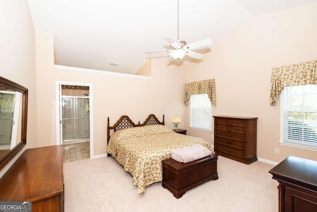 carpeted bedroom featuring ceiling fan, ensuite bathroom, and vaulted ceiling