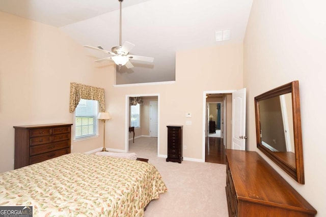 bedroom featuring ceiling fan, light colored carpet, and high vaulted ceiling