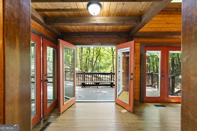 doorway to outside featuring beamed ceiling, wood-type flooring, and french doors