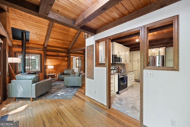 unfurnished living room featuring light hardwood / wood-style flooring, wooden walls, wooden ceiling, and beamed ceiling