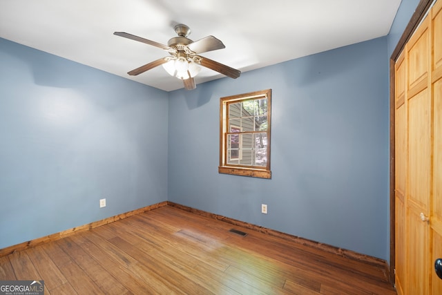 unfurnished bedroom featuring hardwood / wood-style flooring, a closet, and ceiling fan