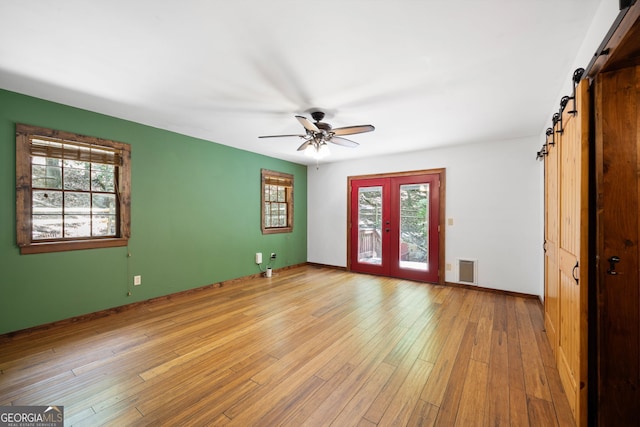 empty room featuring a wealth of natural light, light hardwood / wood-style floors, and ceiling fan