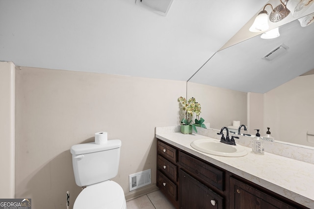 bathroom featuring tile patterned flooring, vaulted ceiling, vanity, and toilet