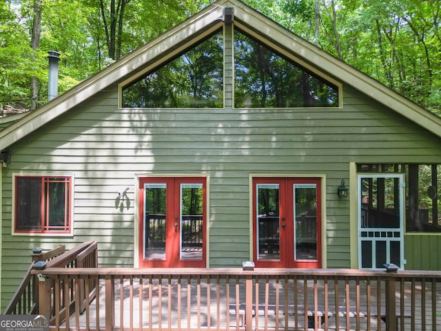 back of property with a wooden deck and french doors