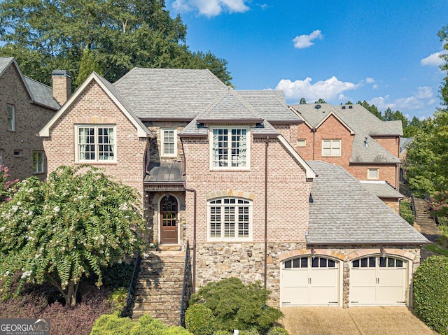 1829 Buckhead Valley Ln NE, Atlanta, GA 30324 - view of front of house with driveway, brick siding, a garage, and roof with shingles