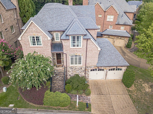 1829 Buckhead Valley Ln NE, Atlanta, GA 30324 - view of front of home with concrete driveway, roof with shingles, an attached garage, stone siding, and a chimney