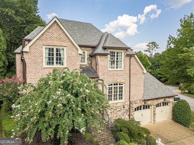 1829 Buckhead Valley Ln NE, Atlanta, GA 30324 - view of front of property with stone siding, an attached garage, brick siding, roof with shingles, and driveway