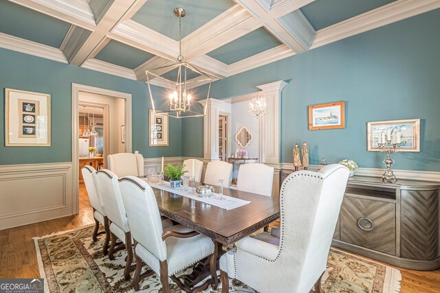 dining room with coffered ceiling, an inviting chandelier, hardwood / wood-style floors, and beam ceiling