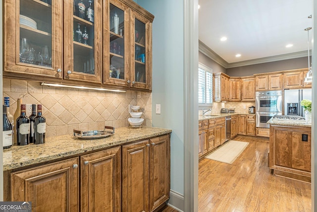 1829 Buckhead Valley Ln NE, Atlanta, GA 30324 - kitchen featuring crown molding, a sink, light stone countertops, appliances with stainless steel finishes, and light wood-style flooring