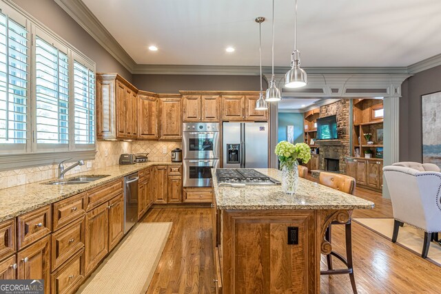 kitchen featuring a center island, wood-type flooring, stainless steel appliances, and crown molding