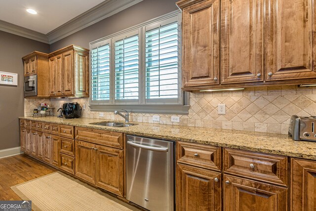 kitchen featuring light wood-type flooring, appliances with stainless steel finishes, a wealth of natural light, and sink