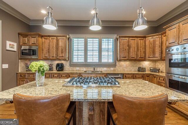 kitchen featuring appliances with stainless steel finishes, a kitchen island, and light stone countertops