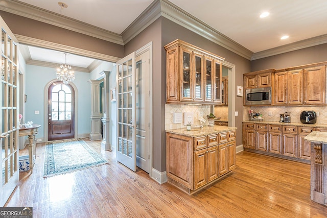 1829 Buckhead Valley Ln NE, Atlanta, GA 30324 - kitchen featuring stainless steel microwave, brown cabinetry, glass insert cabinets, and light stone counters