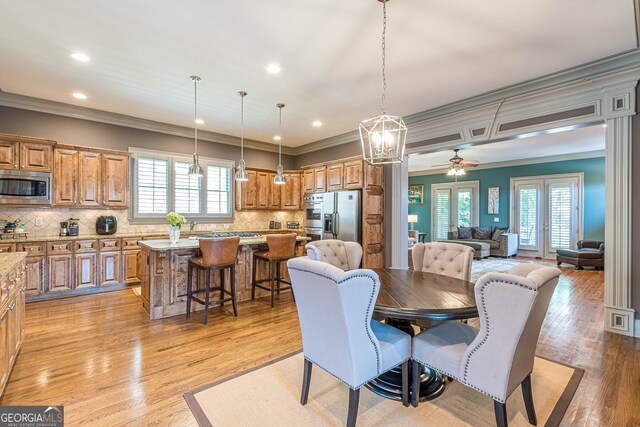 dining area with ceiling fan, ornamental molding, french doors, and light hardwood / wood-style floors