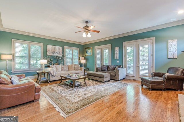 living room featuring ceiling fan, ornamental molding, light wood-type flooring, and french doors