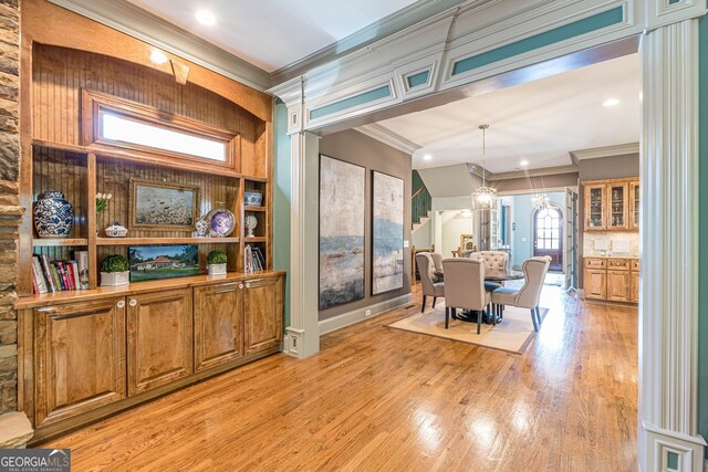 dining area featuring crown molding, a chandelier, and light hardwood / wood-style floors