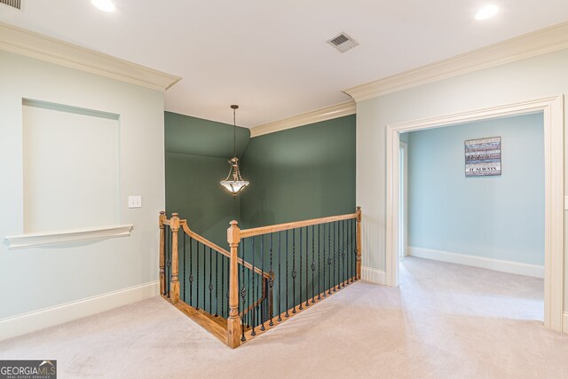 hallway with ornamental molding and carpet floors