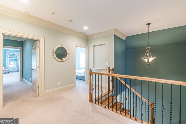 corridor with crown molding and light colored carpet