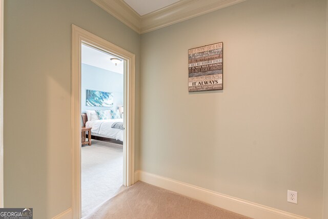 hall with crown molding and light colored carpet