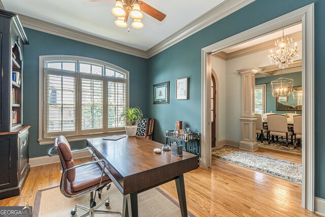 office area featuring light hardwood / wood-style flooring, ornamental molding, ceiling fan with notable chandelier, and decorative columns