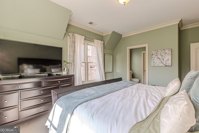 carpeted bedroom featuring crown molding and connected bathroom