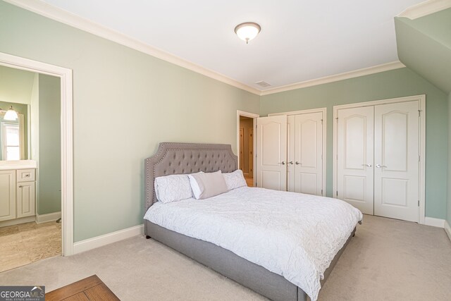 bedroom with light carpet, ornamental molding, and multiple closets