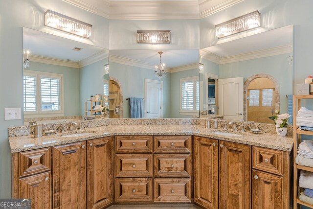 bathroom featuring crown molding, vanity, and a chandelier