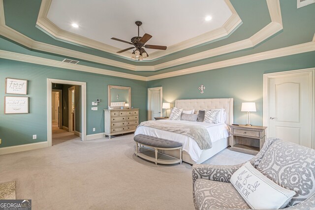 bedroom with a tray ceiling, ceiling fan, light carpet, and ornamental molding